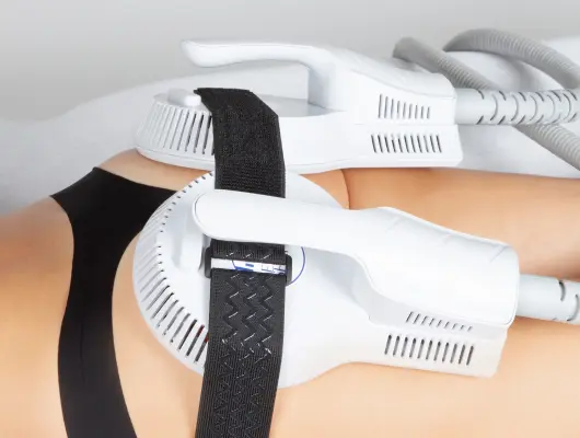 elettrostimolazione-ems Una donna sul suo letto tocca con una piuma la sua pelle liscia e priva di peli grazie al trattamento laser effettuato presso la Novaskin Clinic di Bruxelles.