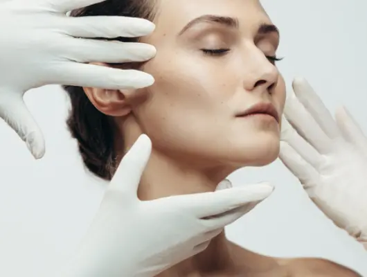 microneedling-viso Una donna sul suo letto tocca con una piuma la sua pelle liscia e priva di peli grazie al trattamento laser effettuato presso la Novaskin Clinic di Bruxelles.